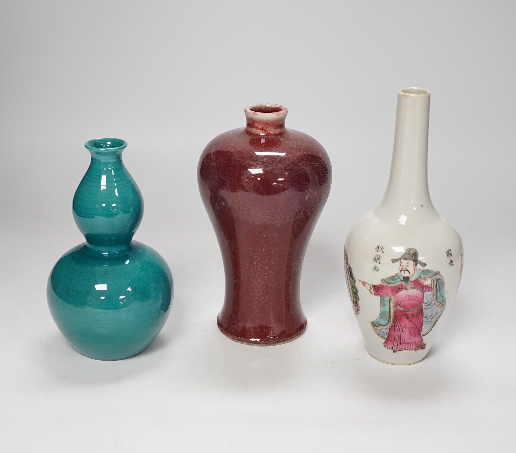 A Chinese double gourd vase, a sang de boeuf vase and a famille rose vase, 18cm high